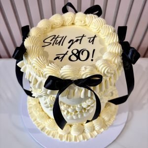 vintage lambeth round birthday cake with buttercream piping and black bows by Sweet Story cake studio