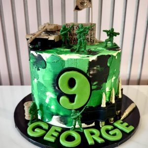 Army themed birthday cake with green camouflage buttercream, toy soldiers, tank and bullet decorations