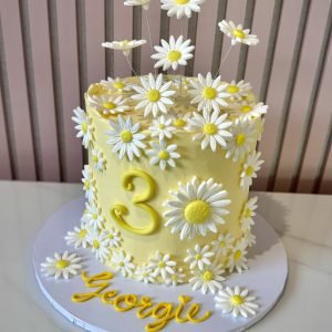 Yellow buttercream daisy birthday cake with white fondant flowers and elevated floral decoration