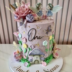 Enchanted fairy birthday cake with pastel colours, butterflies, flowers and fairy toppers with personalised name on front