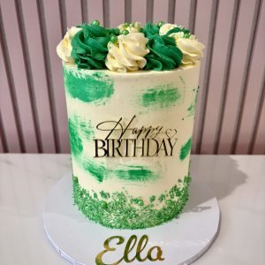 green buttercream birthday cake with brushstroke design, piped swirls and pearl decorations