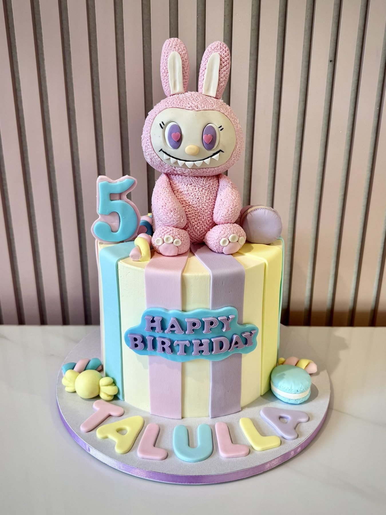 Labubu themed birthday cake with pastel buttercream, bunny character topper and colourful sweet decorations