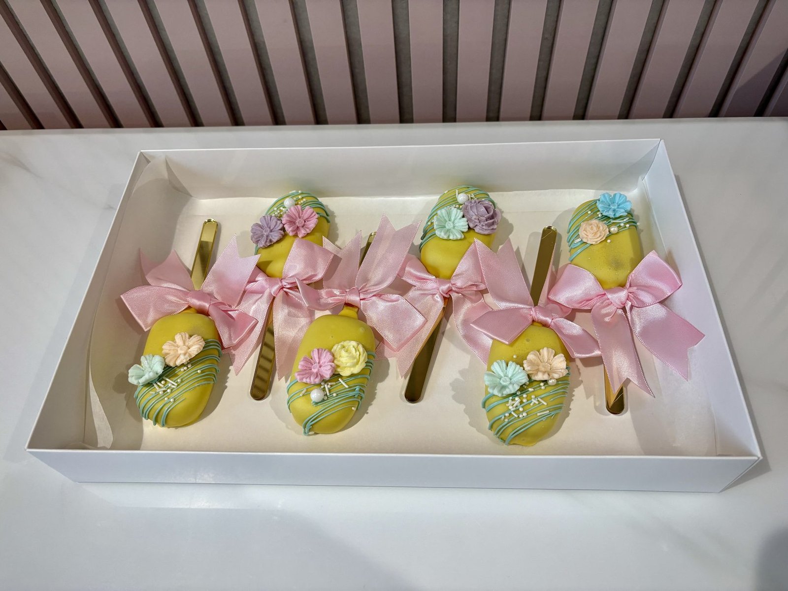 Luxury floral cakesicles with pastel flowers and ribbon presentation by Sweet Story cake studio