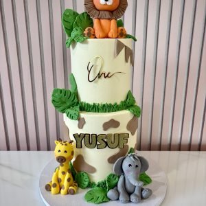 Two tier safari cake with lion topper and jungle animals by Sweet Story cake studio