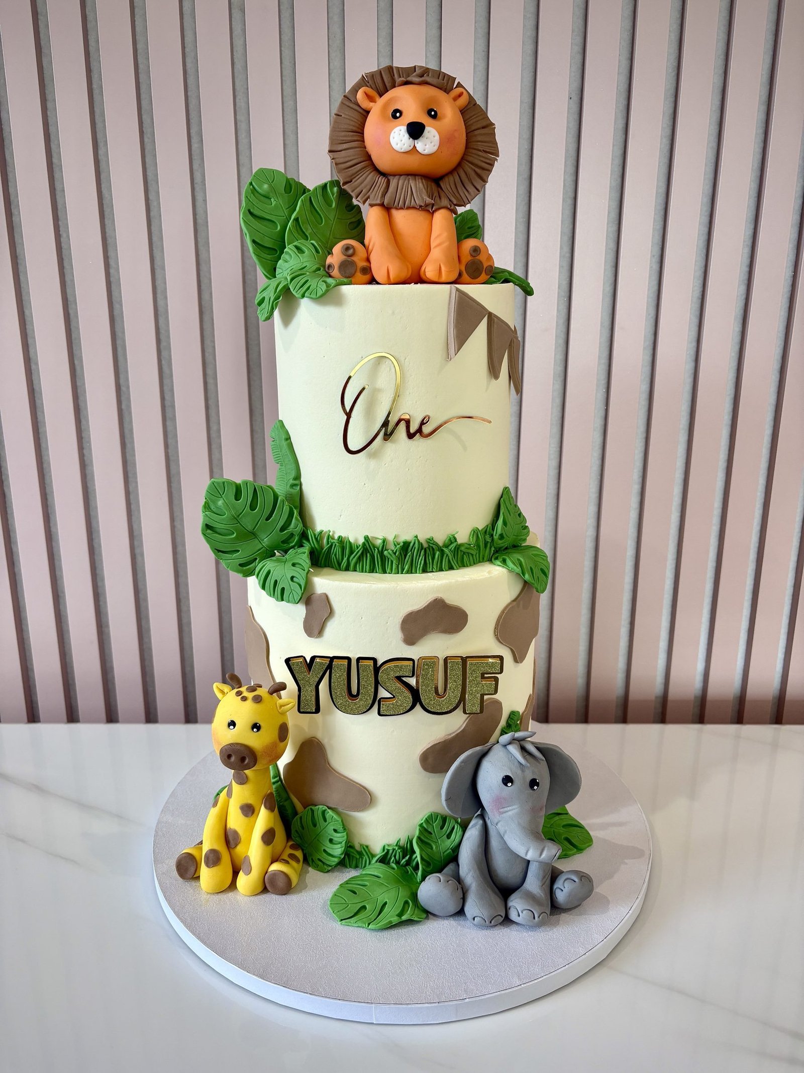 Two tier safari cake with lion topper and jungle animals by Sweet Story cake studio