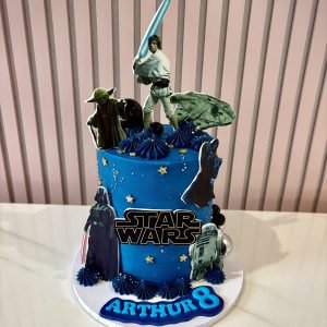 Star Wars themed birthday cake with galaxy design, character toppers and blue space background
