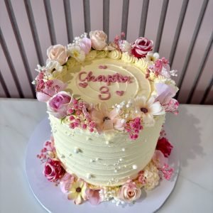 Ivory anniversary cake with blush pink flowers, pearl details and anniversary year topper.