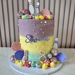 Bowling themed birthday cake with pastel buttercream, bowling pins, balls and disco ball decorations