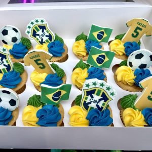 Brazil football themed cupcakes with personalised shirt toppers, football decorations and yellow green and blue buttercream swirls