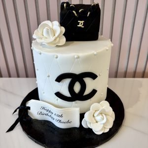 Luxury Chanel-inspired birthday cake with quilted detailing, pearl accents, sugar camellias and a designer handbag topper.