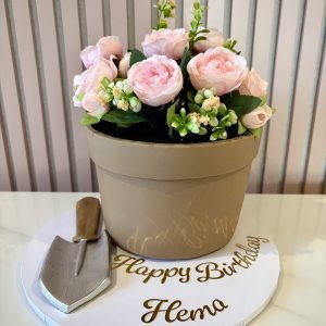 Flower pot cake with realistic pot design, artificial pink flowers, greenery and garden trowel decoration