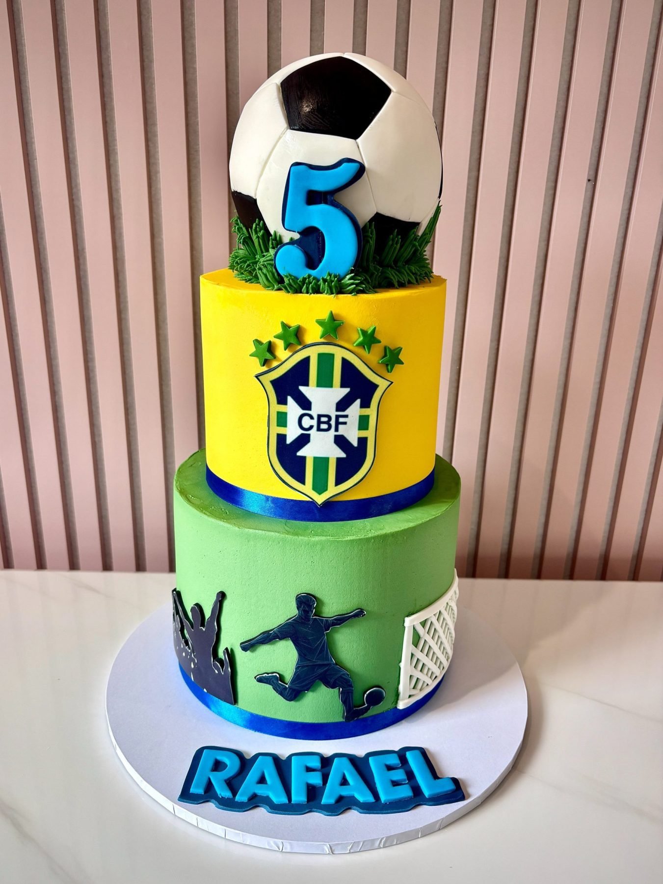 Two tier football birthday cake with large football topper and Brazil inspired football theme