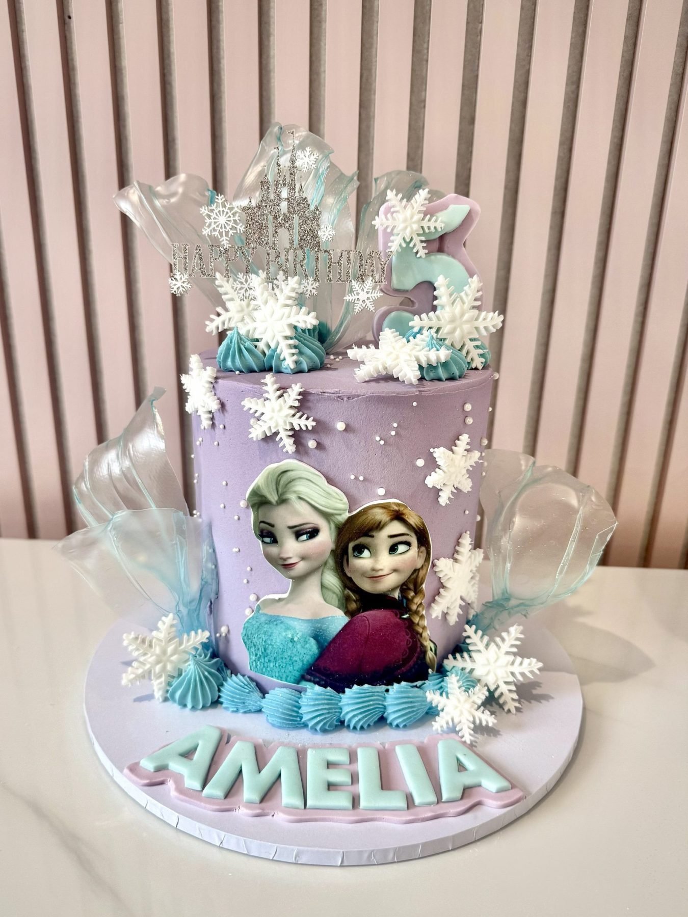 Frozen inspired birthday cake with Elsa and Anna decorations, snowflakes and ice-effect sugar sails