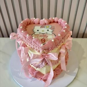 Heart-shaped Hello Kitty birthday cake with pink vintage piping, ribbon bows and personalised Hello Kitty topper.