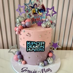 KPop Demon Hunters birthday cake with pastel colours, glitter stars, disco balls and themed toppers