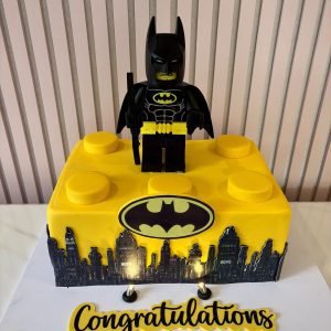 Lego Batman birthday cake for boys with giant Lego brick design, Gotham City skyline and Lego Batman figure topper.