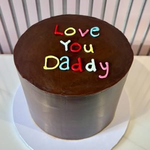 Simple chocolate birthday cake with colourful Love You Daddy piping and smooth chocolate finish