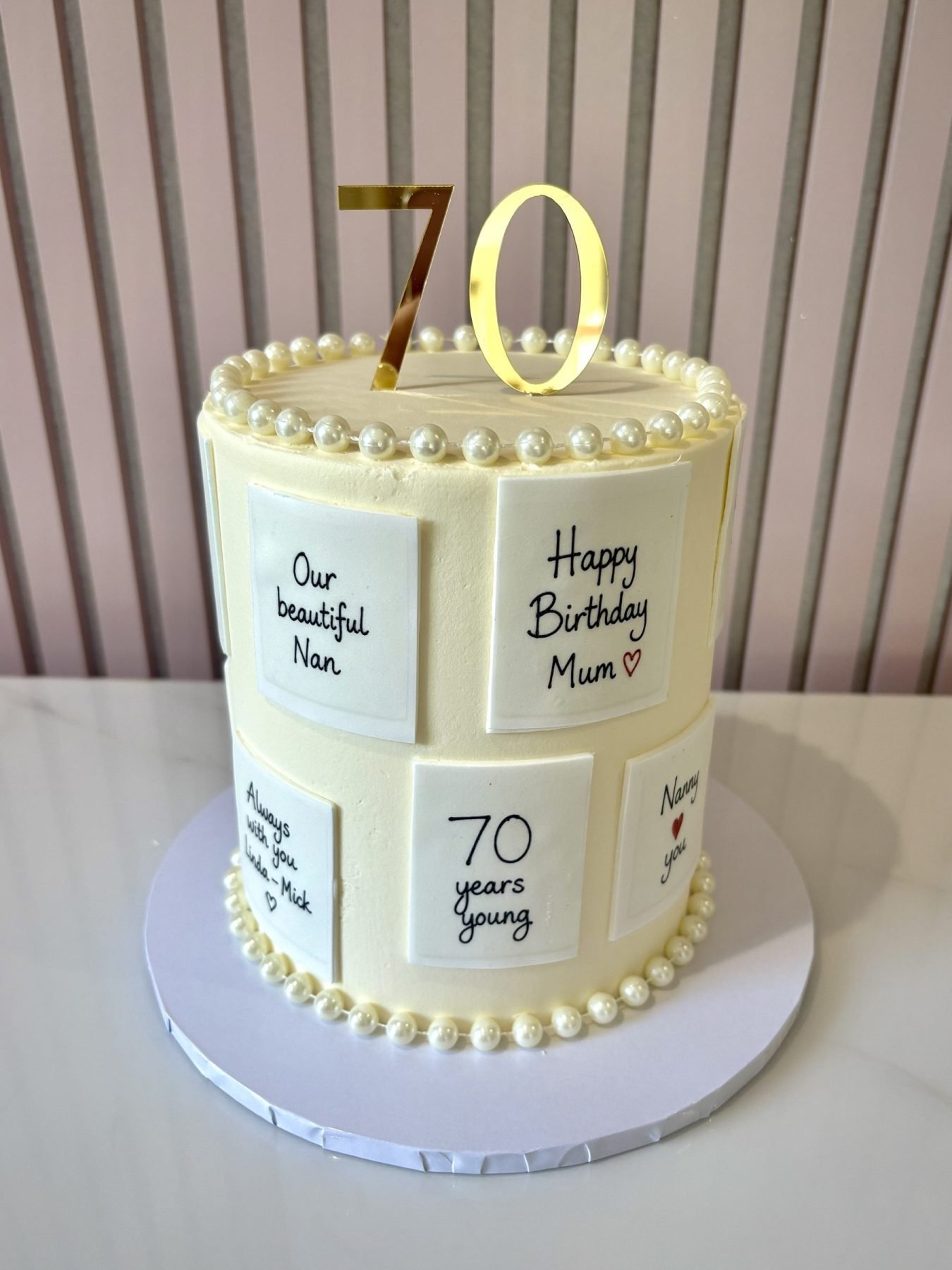 Elegant buttercream birthday cake with personalised message card details and pearl decoration