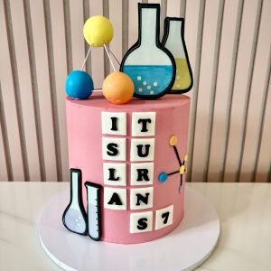 Science themed birthday cake with buttercream finish, lab beakers and personalised name tiles
