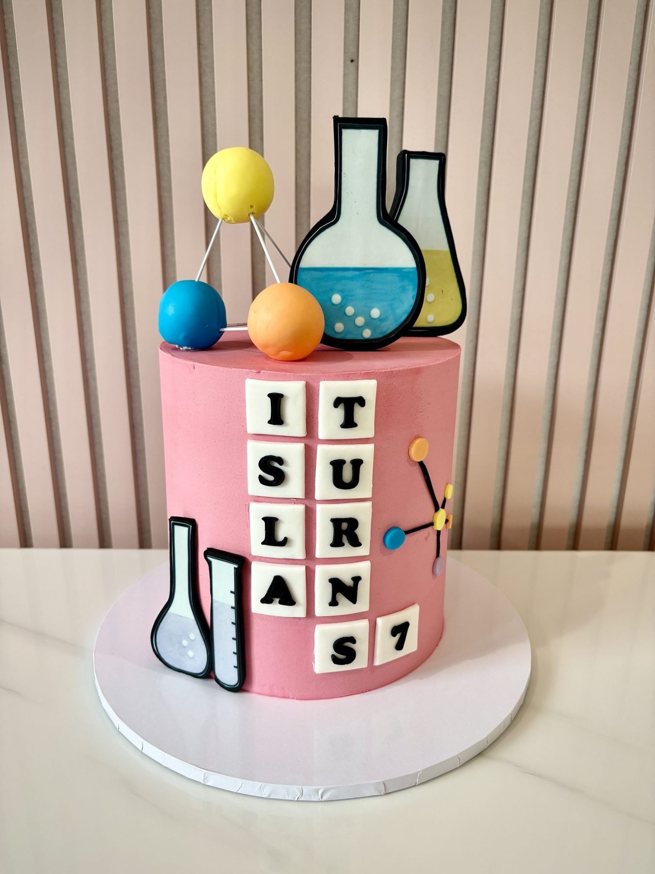 Science themed birthday cake with buttercream finish, lab beakers and personalised name tiles