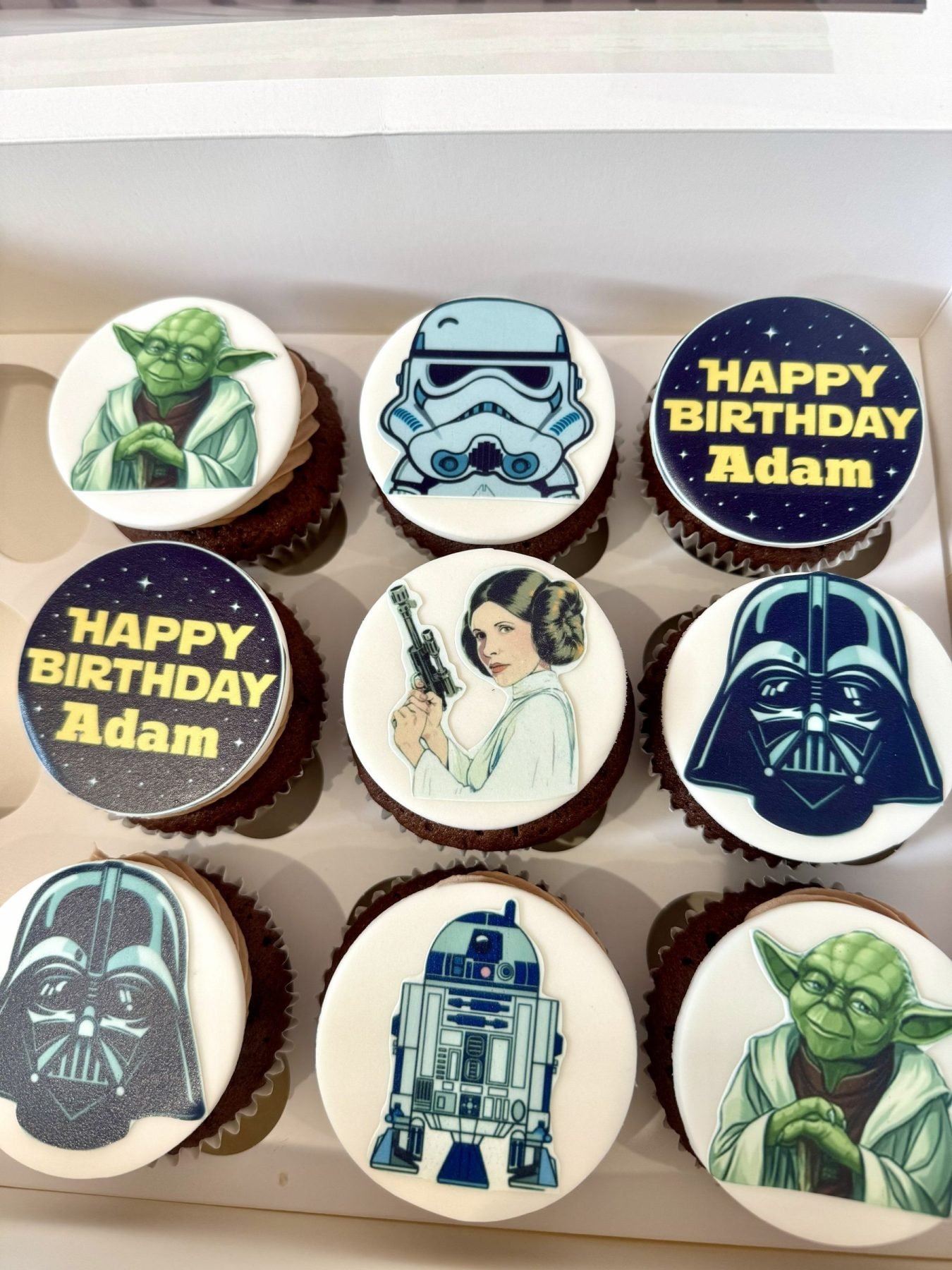 Star Wars themed cupcakes with edible toppers featuring Darth Vader, Yoda, Princess Leia, Stormtrooper and R2-D2 designs