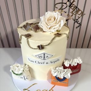 Luxury inspired buttercream birthday cake with handcrafted necklace and earring details and designer inspired decorations