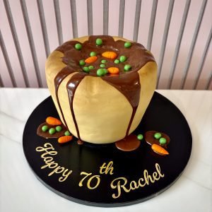 Novelty Yorkshire pudding birthday cake decorated with realistic gravy, peas and carrots.