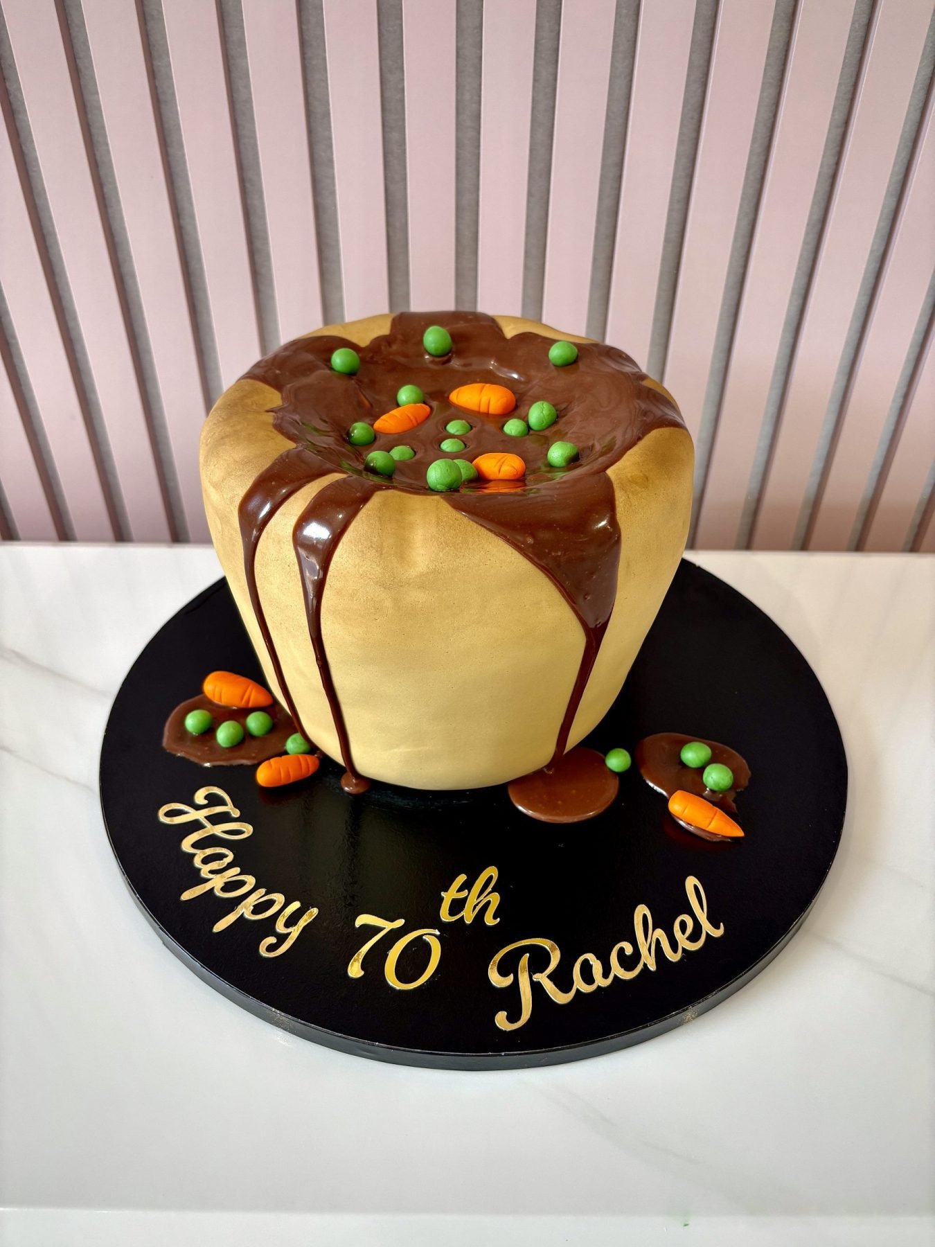 Novelty Yorkshire pudding birthday cake decorated with realistic gravy, peas and carrots.